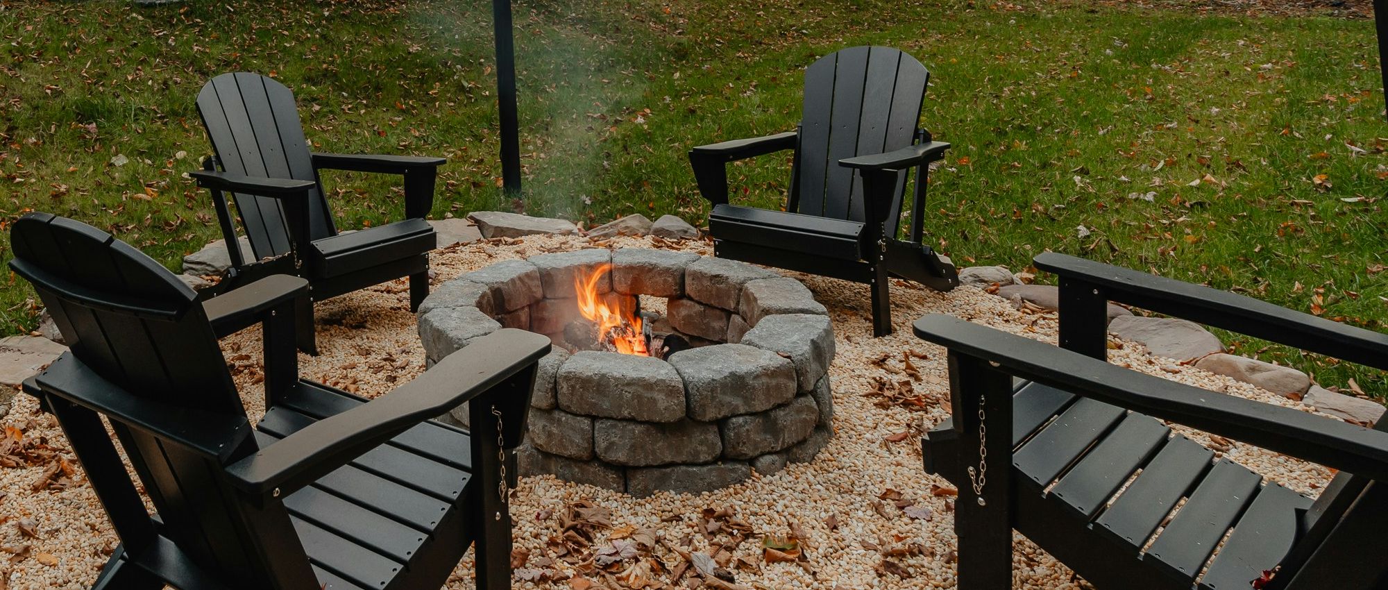 Adirondack chairs gathered around a stone fire pit