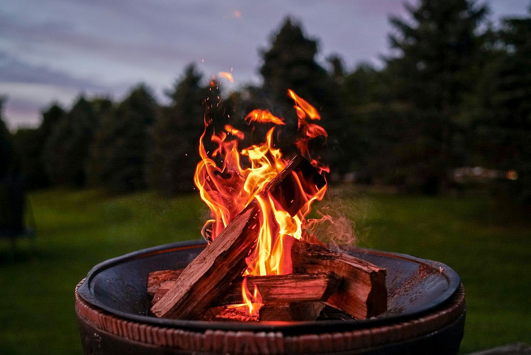A fire burning in a fire bowl at dusk