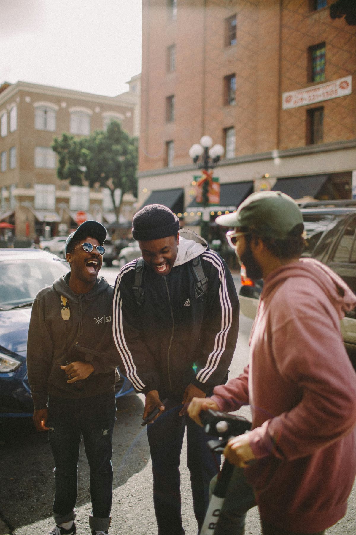 Three men laughing together on a city street